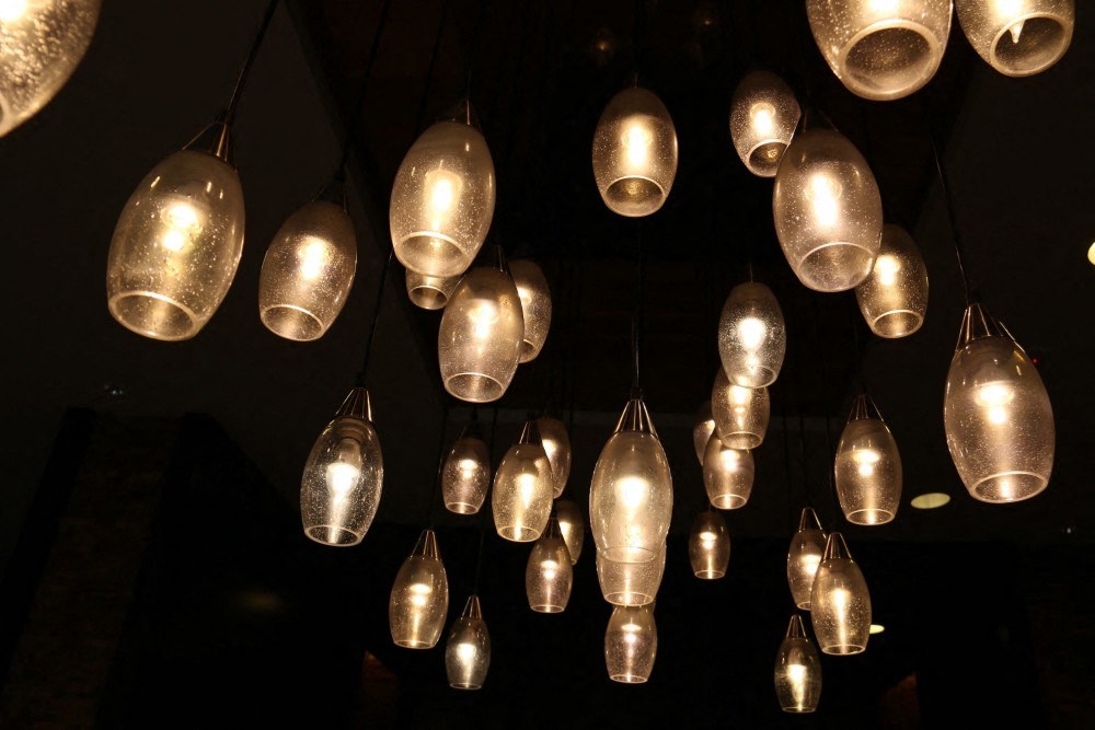 a bunch of lights hanging from the ceiling in a dark room