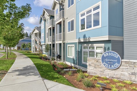 A row of townhouses with a sign that says Briggs Apartments Village.