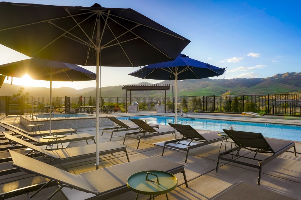 A sunny day at the pool with lounge chairs and umbrellas.