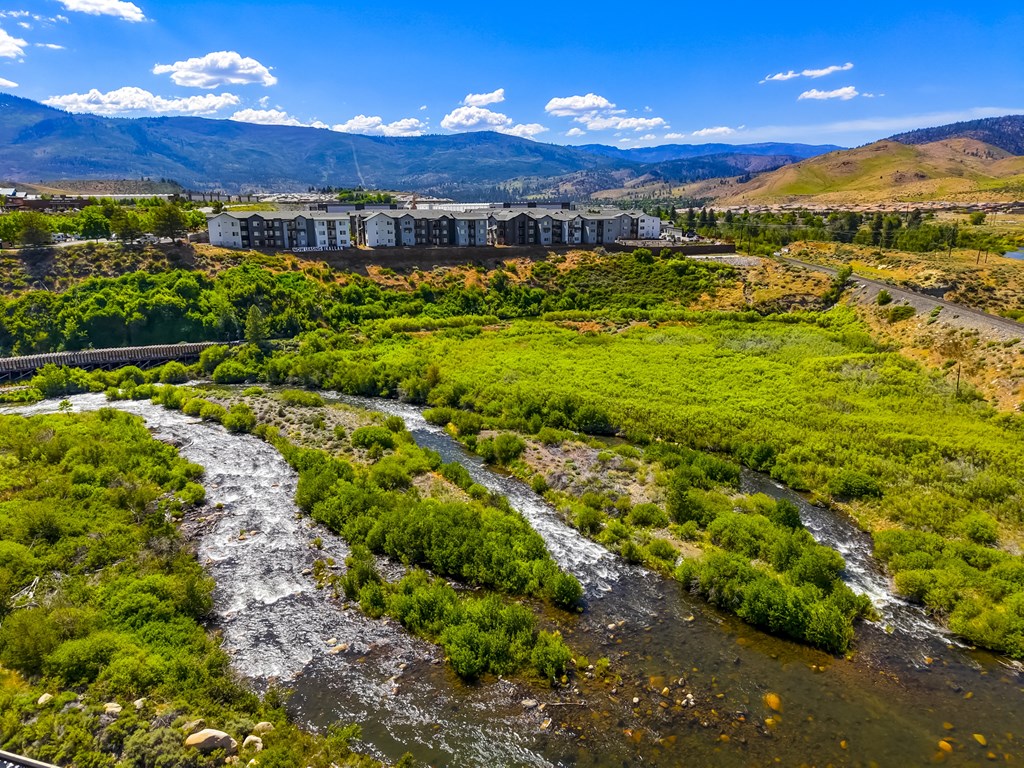 A river flows through a green valley with mountains in the background.