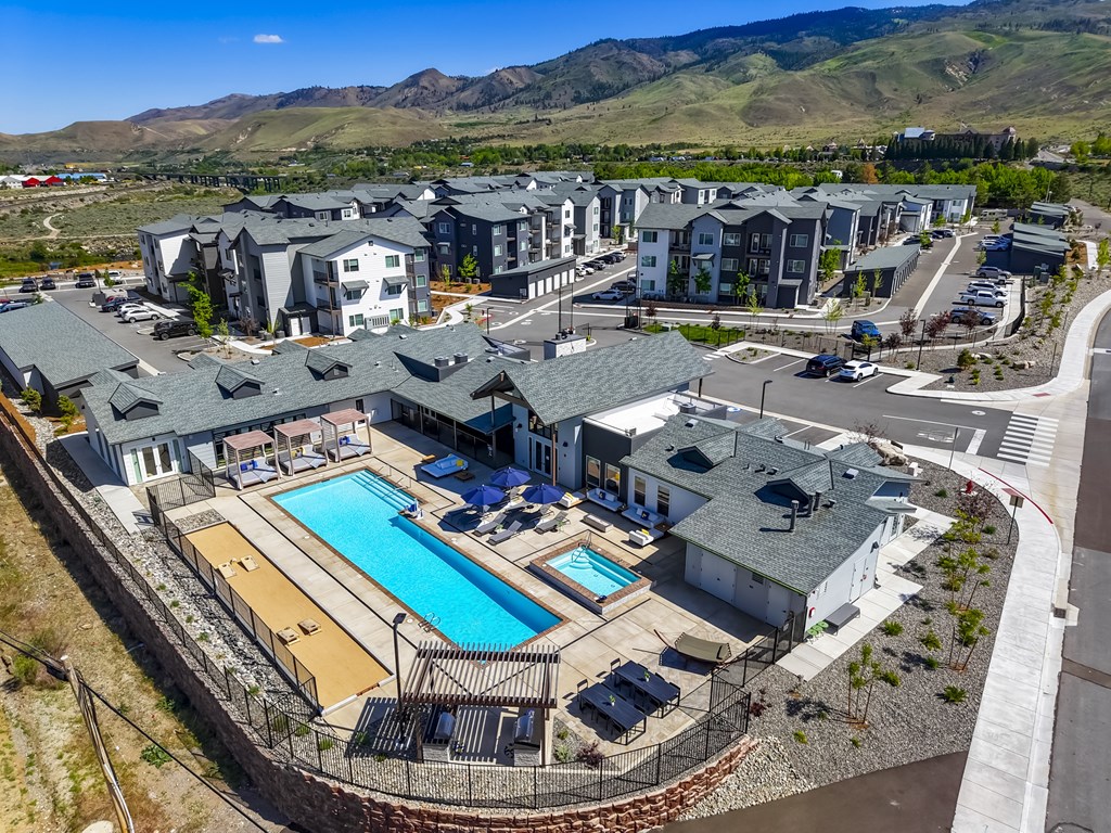 A large swimming pool surrounded by houses and a fence.