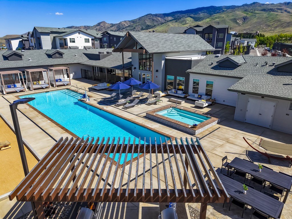 A large outdoor swimming pool with a wooden deck in front.