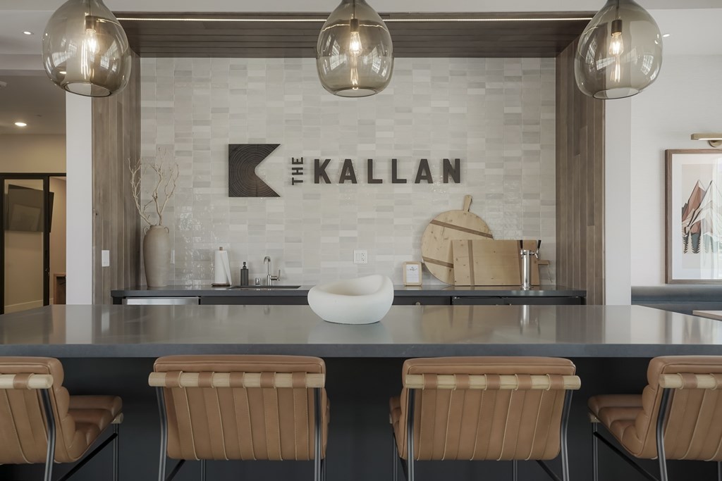 A modern kitchen with a large island and chairs.