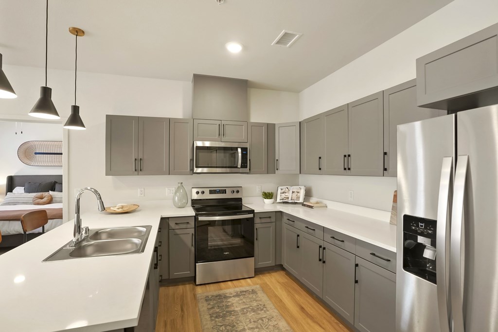 A modern kitchen with a stainless steel refrigerator and a white countertop.