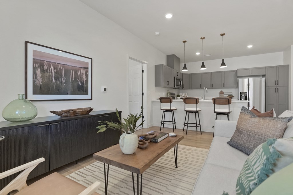 a living room and kitchen with a couch and a table