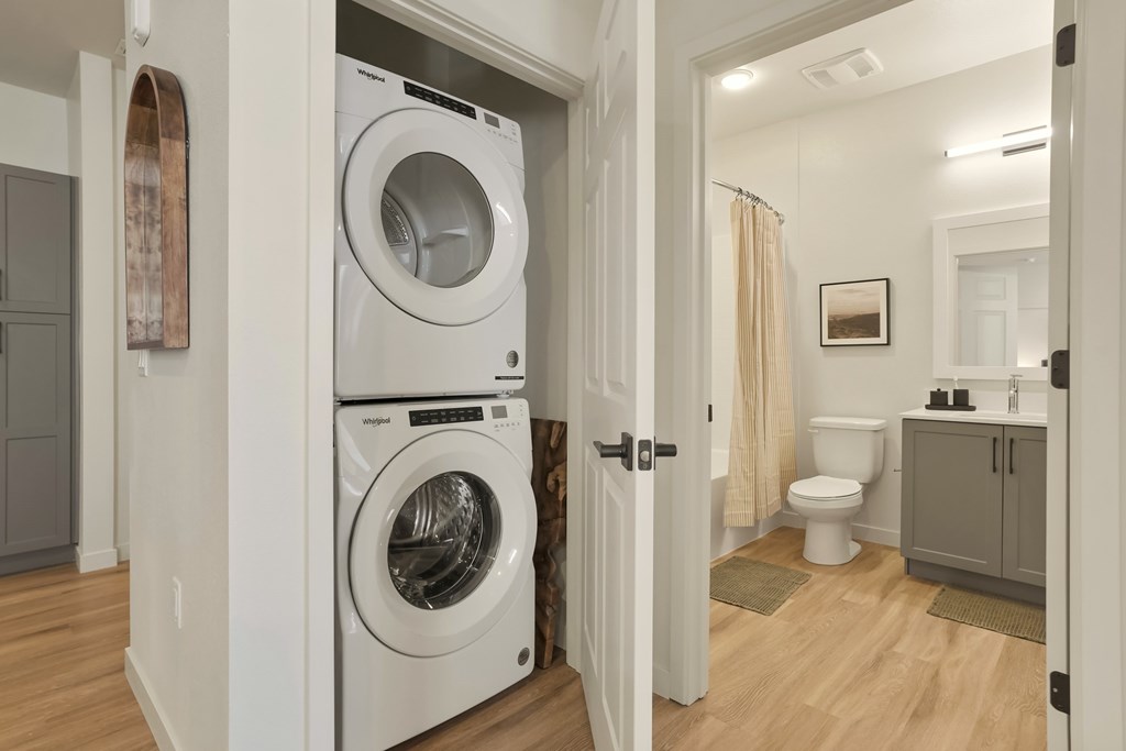 A white washing machine is in a small laundry room.