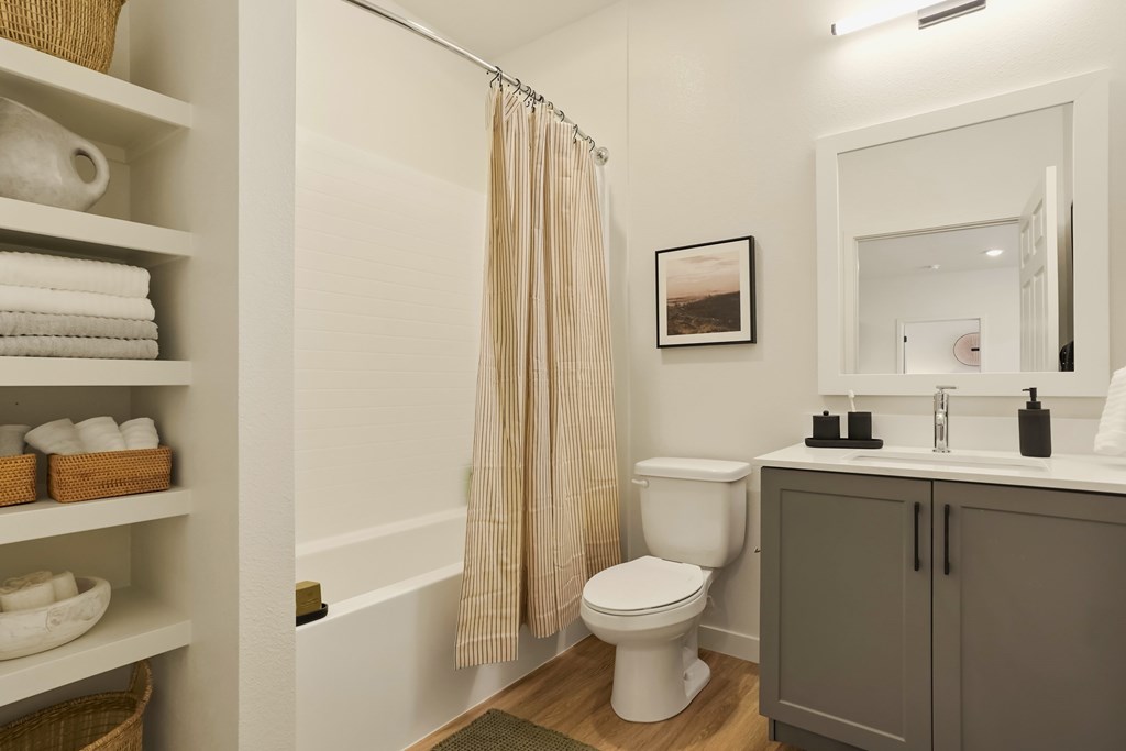A bathroom with a toilet, sink, and a shower curtain.