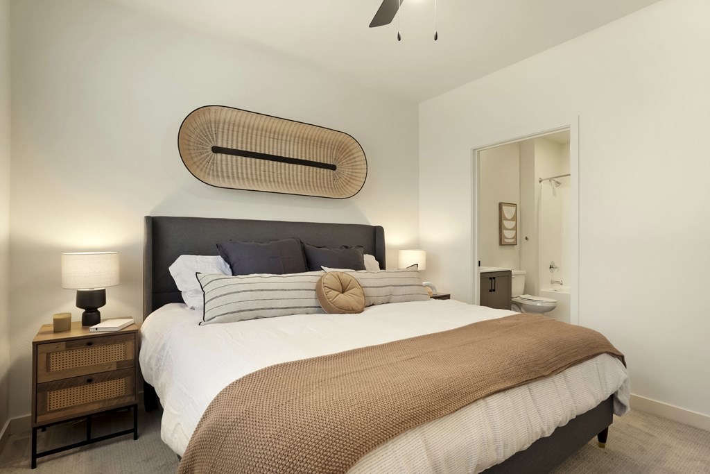 A bedroom with a large bed and a wooden headboard.