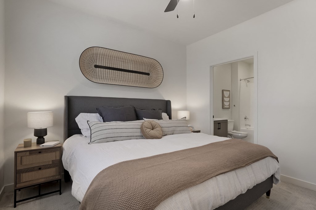 a bedroom with a large bed and a bathroom with a toilet