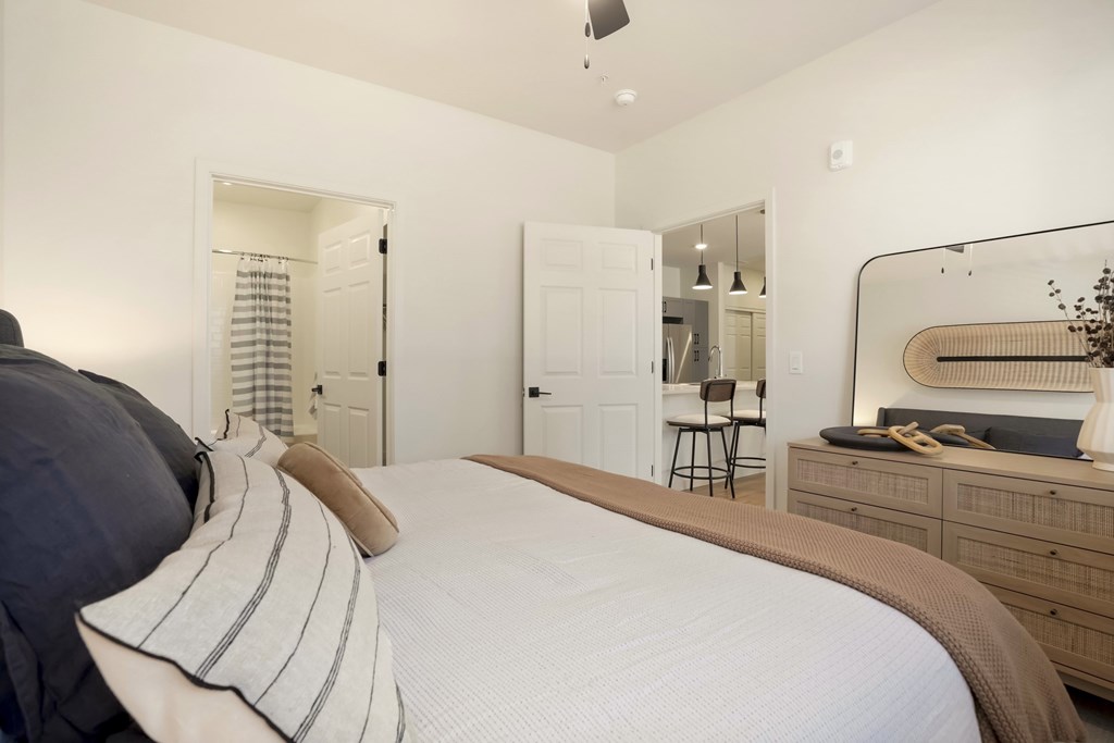 A bedroom with a large bed and a mirror on the wall.