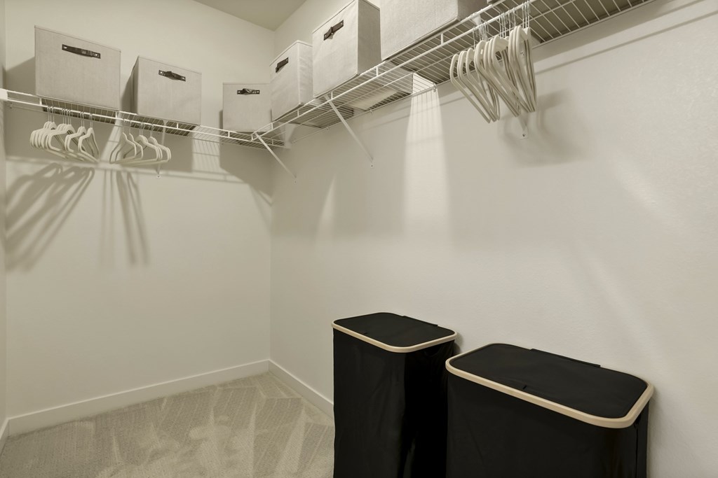 A laundry room with a clothes dryer and a clothes rack.