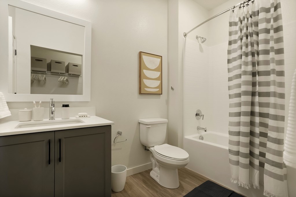 A bathroom with a toilet, sink, and shower.