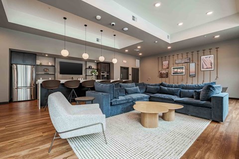 A modern living room with a grey sofa, a white chair, and a wooden coffee table.