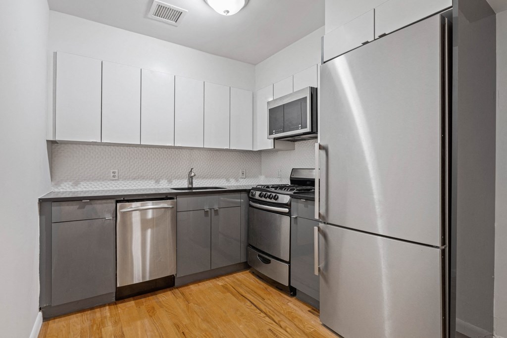 a kitchen with stainless steel appliances and white cabinets