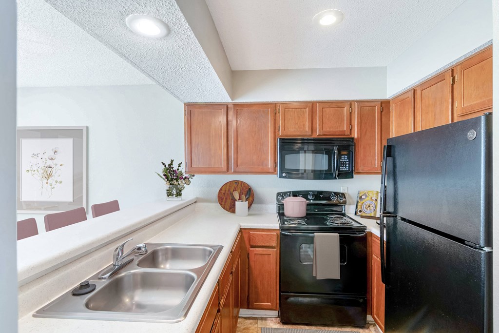 a kitchen with black appliances and wooden cabinets