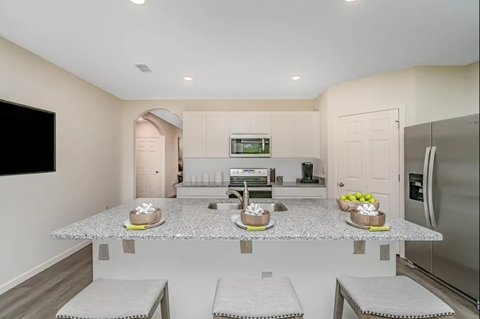 A kitchen with a granite countertop and stainless steel appliances.