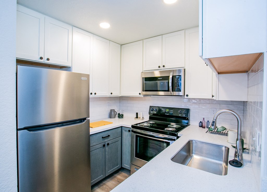 a kitchen with stainless steel appliances and white cabinets