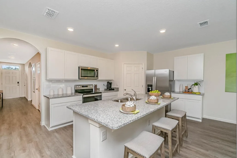 A kitchen with a counter and stools.