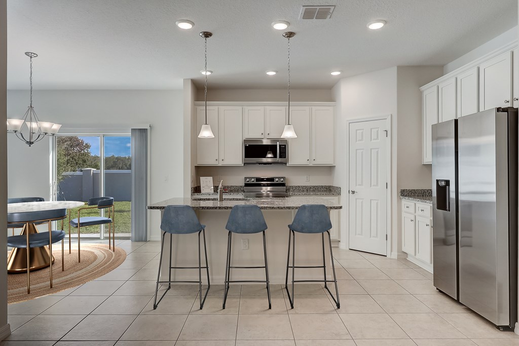 A modern kitchen with a bar area and a refrigerator on the right.