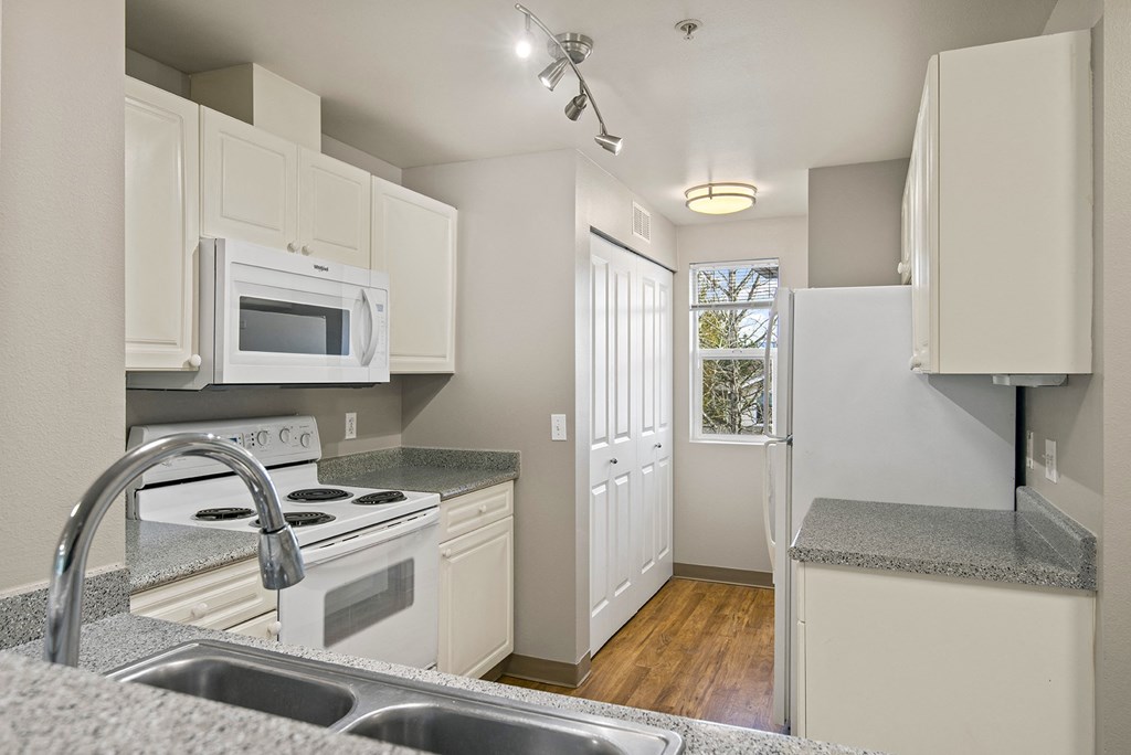 a kitchen with white appliances and granite counter tops