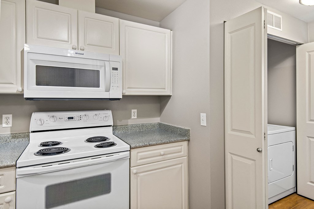 a kitchen with white appliances and white cabinets
