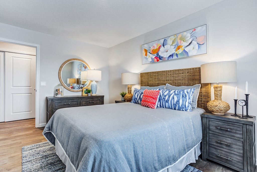 a bedroom with a large bed and a mirror