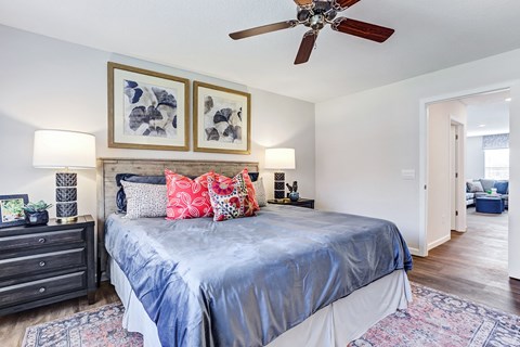 the master bedroom has a large bed and a ceiling fan