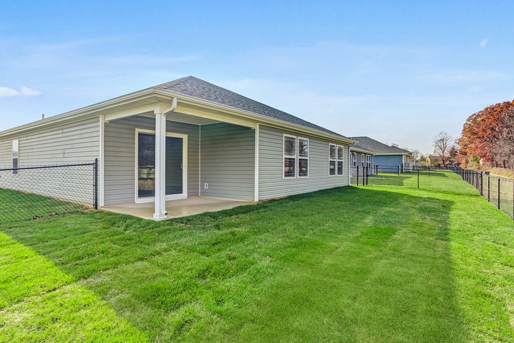 the backyard of a house with a yard and a fence