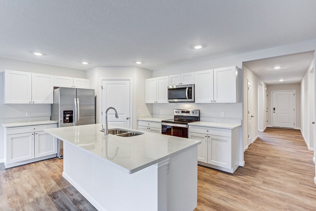 a large kitchen with white cabinets and a white counter top