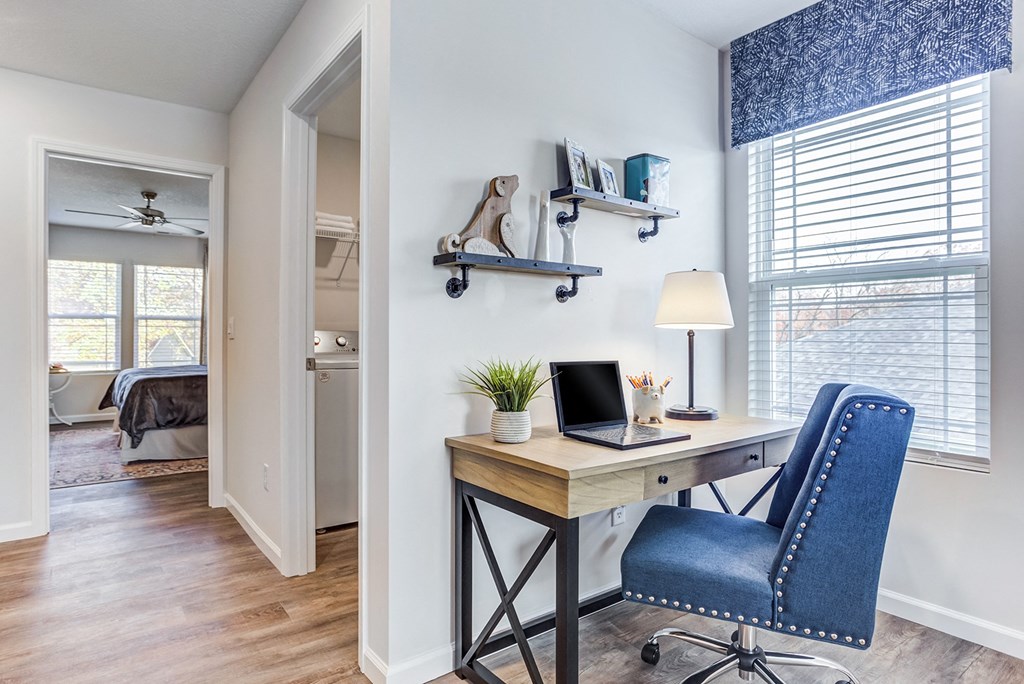 a home office with a desk with a laptop and a chair