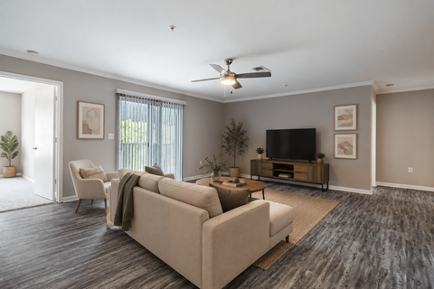 A living room with a couch, chairs, and a television.