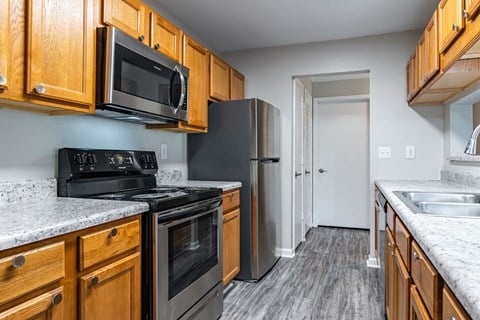 a kitchen with wood cabinets and black appliances and a refrigerator