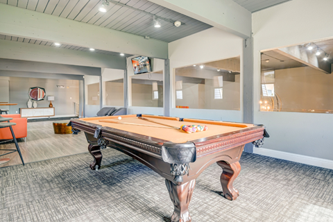 A pool table in a room with a grey carpet.