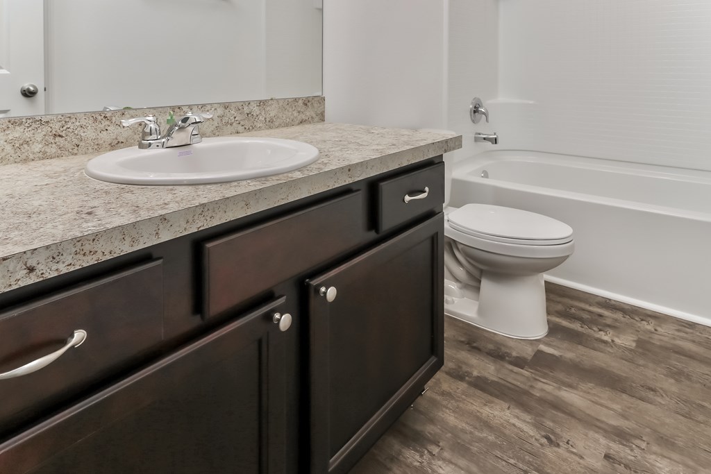 A bathroom with a sink, toilet, and bathtub.