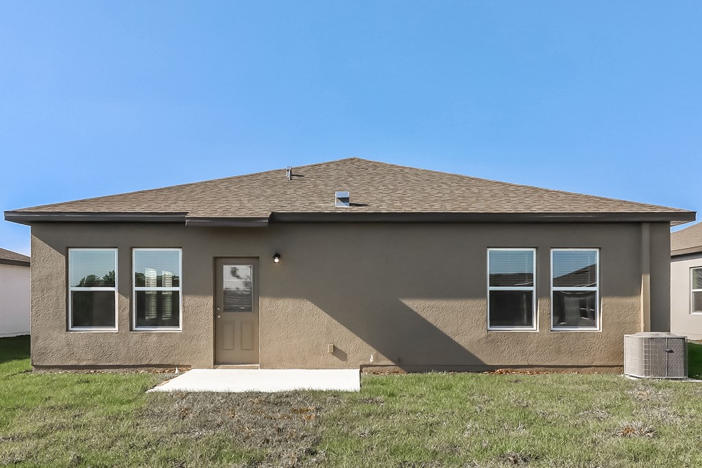 A house with a brown roof and tan walls with a brown door and windows.