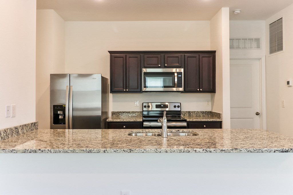 A kitchen with granite countertops and stainless steel appliances.