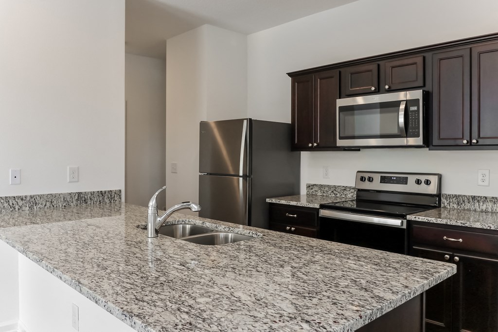 A kitchen with granite countertops and stainless steel appliances.