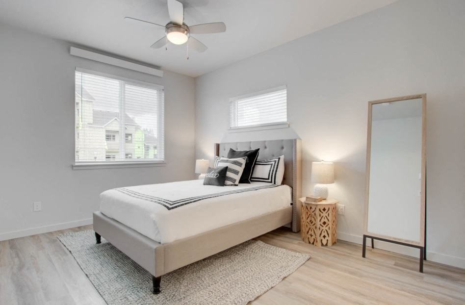 a bedroom with a bed and a ceiling fan and a mirror