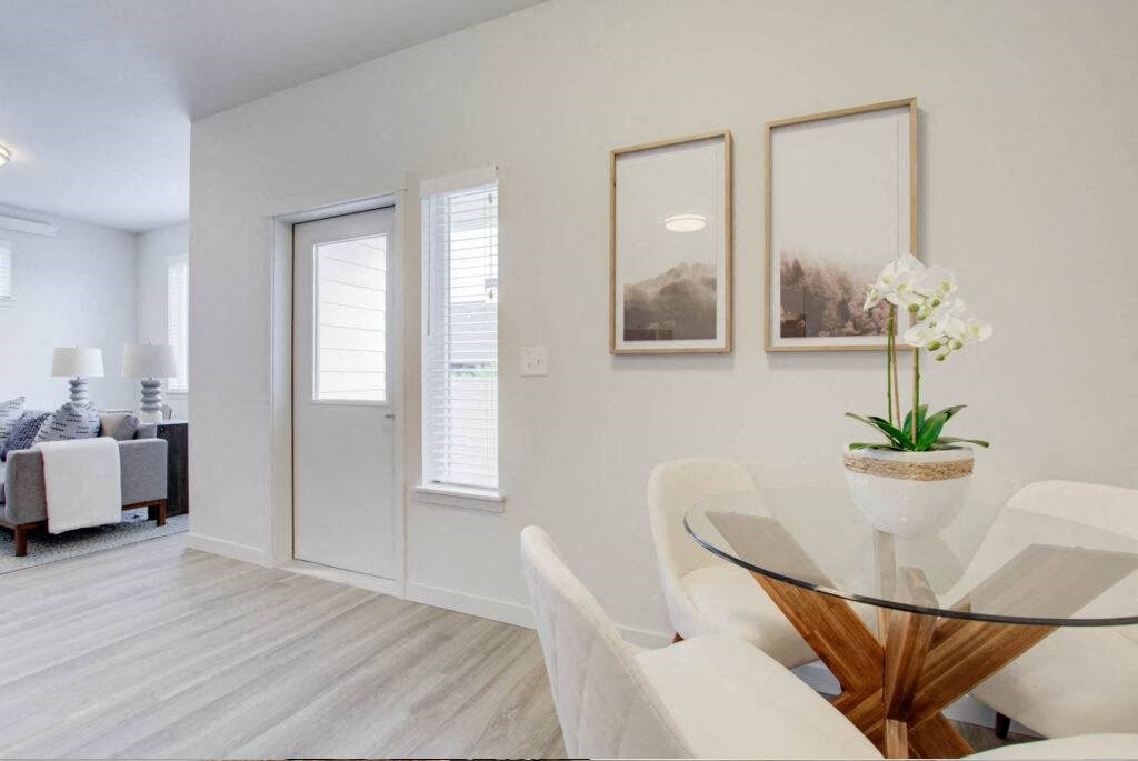 a dining room with white chairs and a glass table