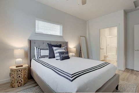 a white bedroom with a large bed and a window