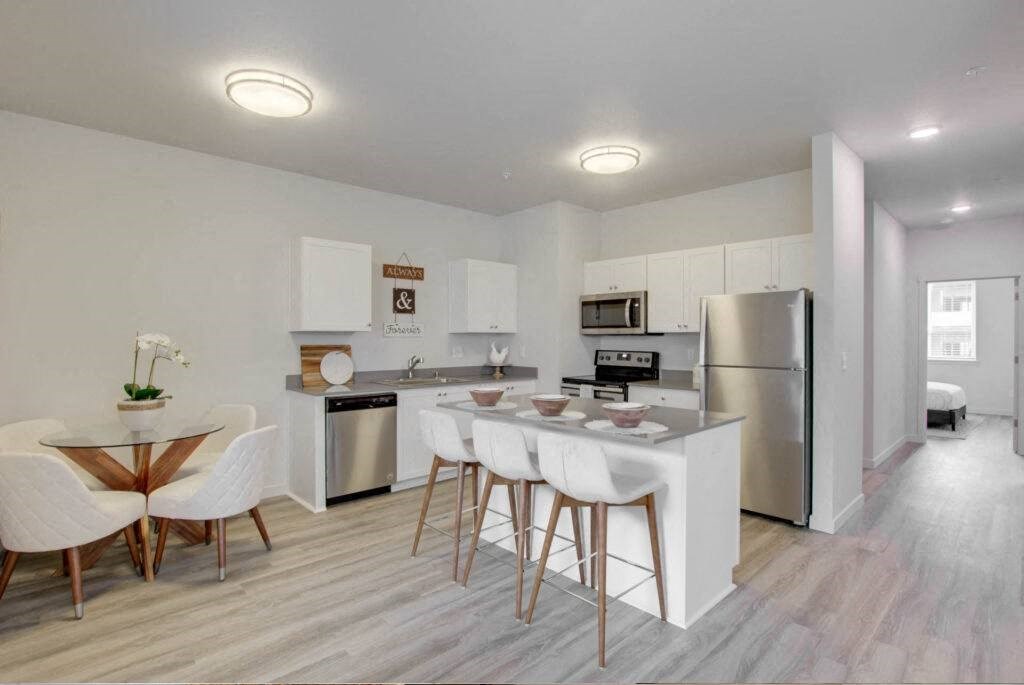 a kitchen with a bar and a table with chairs