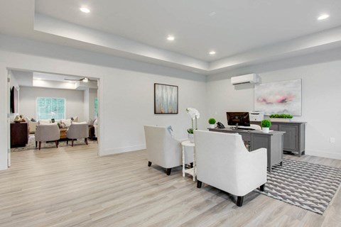 a living room with white chairs and a desk