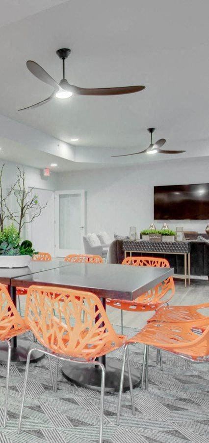 a dining room with orange chairs and a table