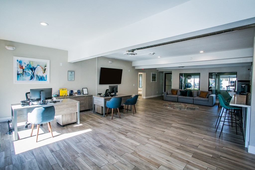 a living room with a desk and chairs and a couch