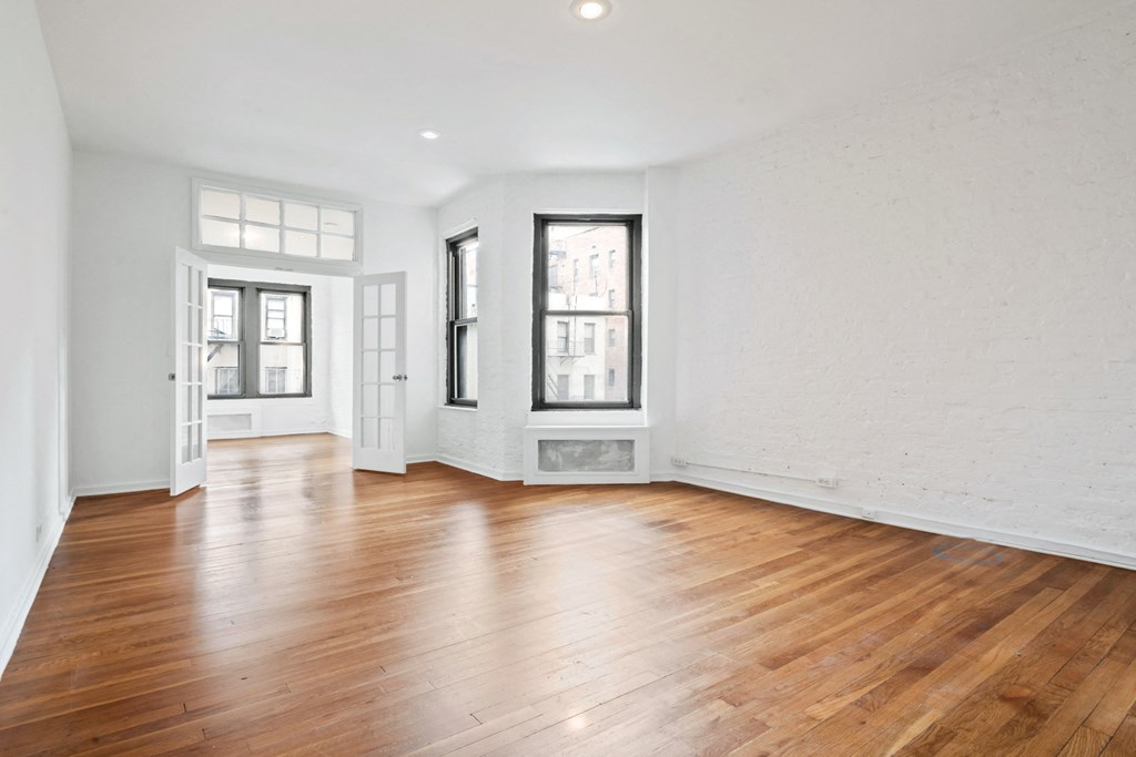 an empty living room with white walls and wood floors