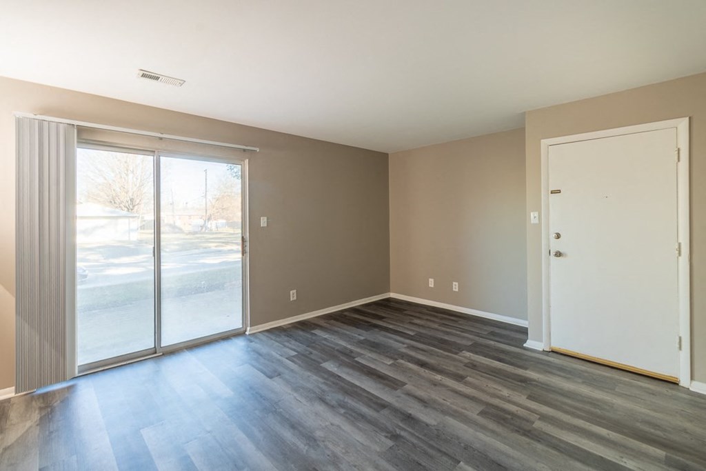 a bedroom with a sliding glass door and hardwood floors