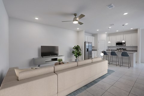 A modern living room with a large couch and a television.