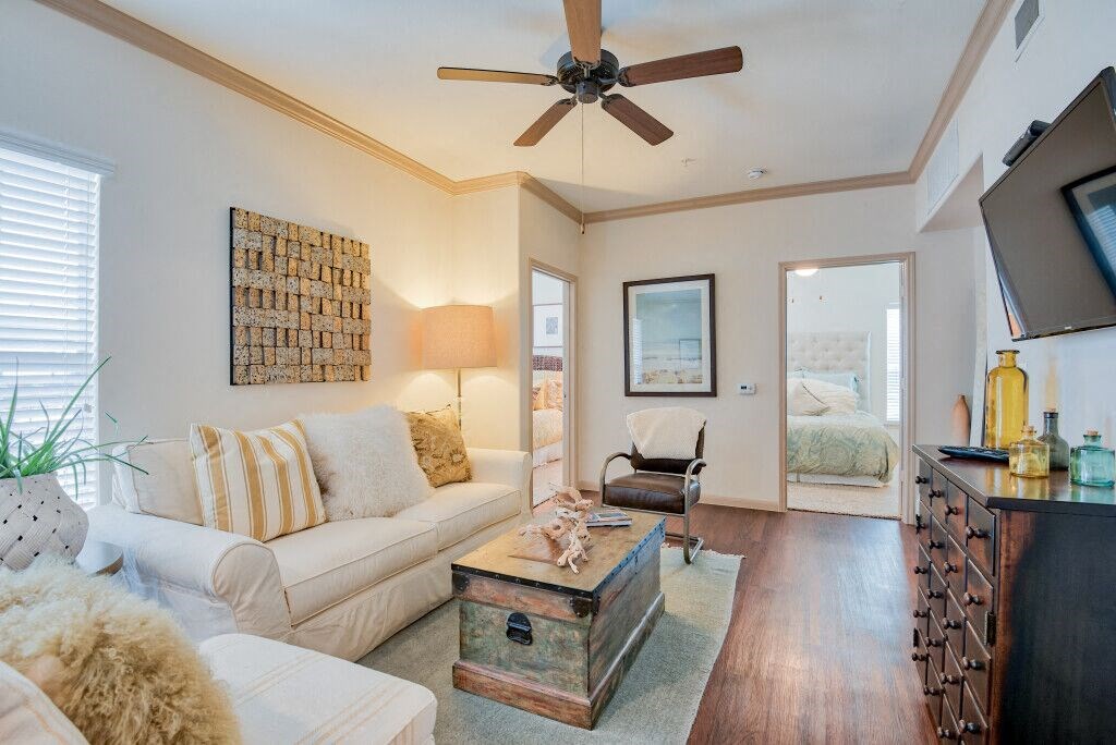 Living room with wood floors and couches and chairs and windows with blinds and ceiling light/fan