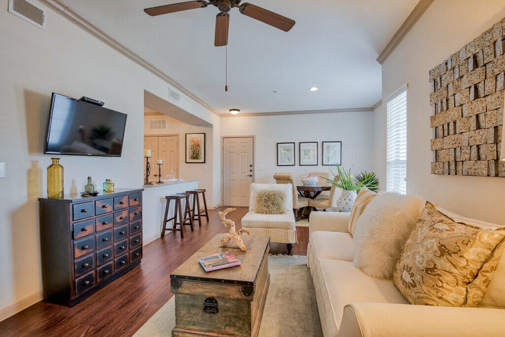 Living room with wood floors and couches and chairs and windows with blinds and ceiling light/fan