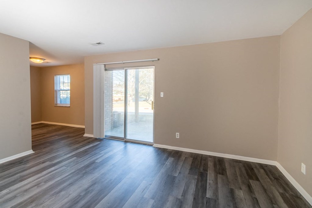 a bedroom with hardwood floors and a sliding glass door to a patio